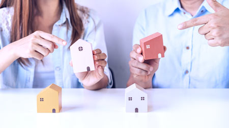 Young couple comparing houses.